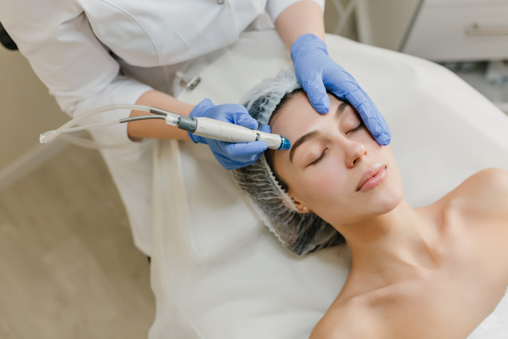 Woman receiving hydrafacial treatment with handheld device by professional.